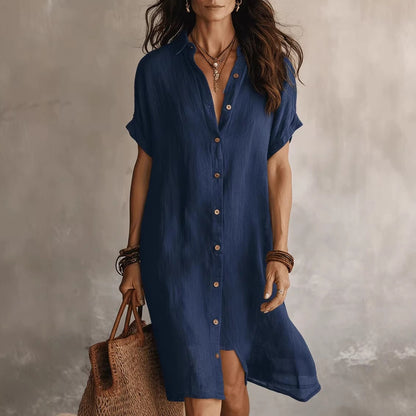 Vestido camisero elegante y casual de largo medio, de color liso, con mangas cortas y cierre de botones.