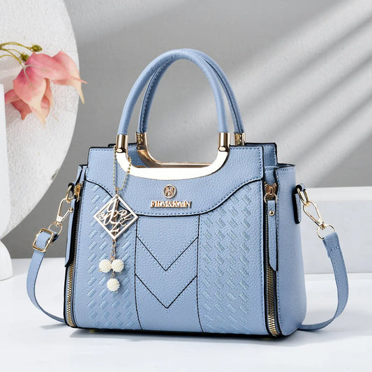 Bolso bandolera para mujer con costuras en forma de V, herrajes dorados, múltiples compartimentos y asa superior.