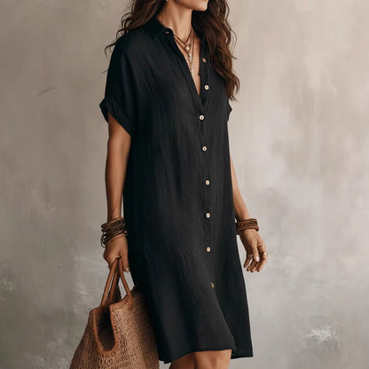 Vestido camisero elegante y casual de largo medio, de color liso, con mangas cortas y cierre de botones.