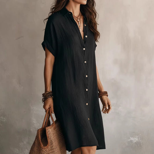 Vestido camisero elegante y casual de largo medio, de color liso, con mangas cortas y cierre de botones.
